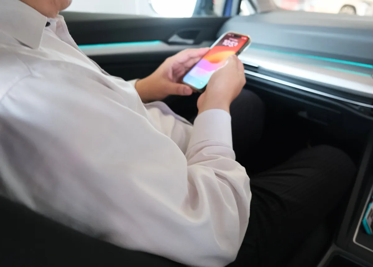 車の中でスマートフォンを操作する手元