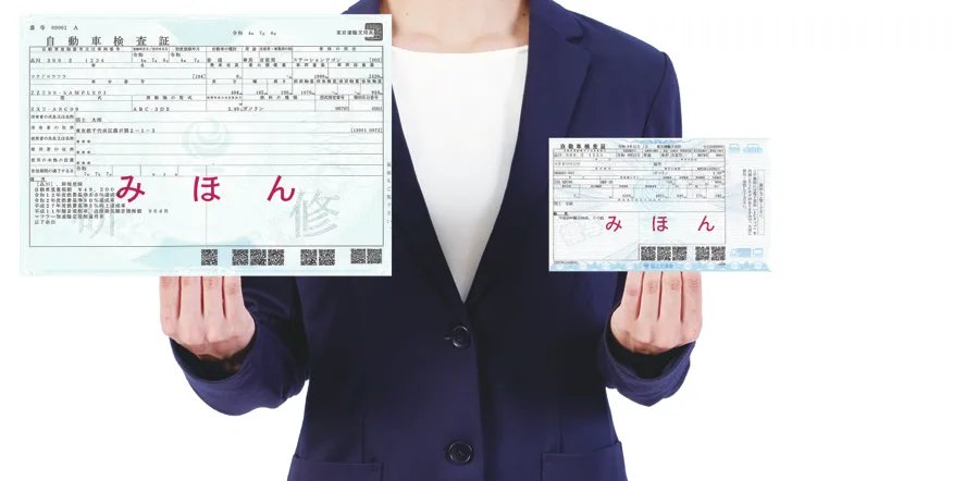 従来のA4の車検証(左)と電子車検証(右)を並べて持った写真。電子車検証は大幅に小さい